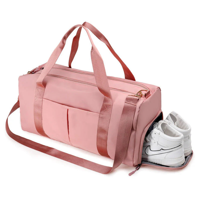 Pink duffel bag with white sneakers inside on a white background